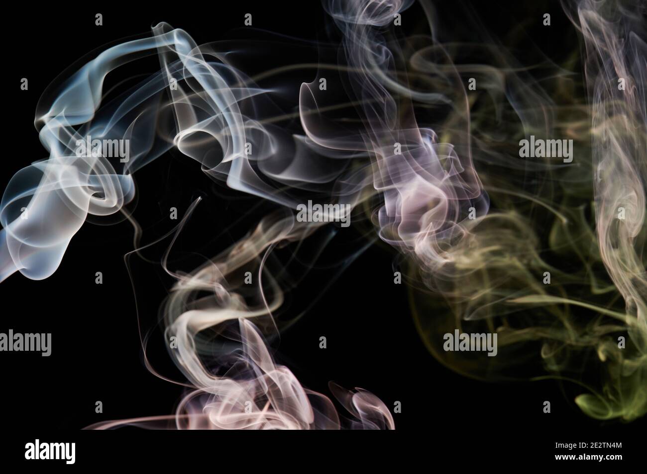 Gelber, lockiger, transparenter Rauch wirbelt auf schwarzem Hintergrund. Magische Wolke Stockfoto