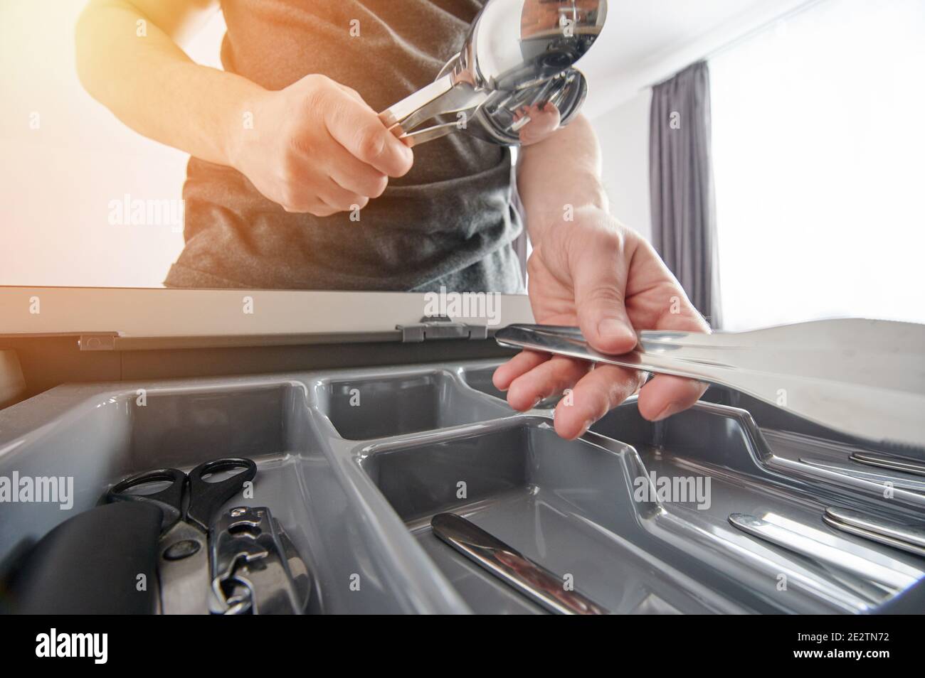 Edelstahl sauberes Kochgeschirr in der Hand auf Kunststoff-Regal Hintergrund Stockfoto