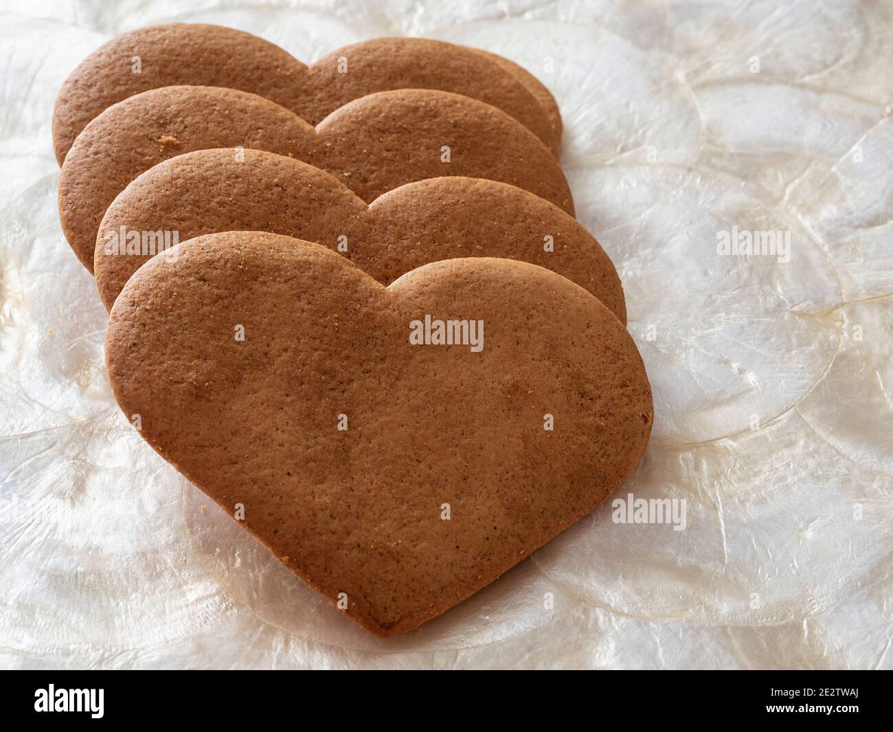 Herzförmige Lebkuchenkekse auf Perlmutt-Tablett Stockfoto