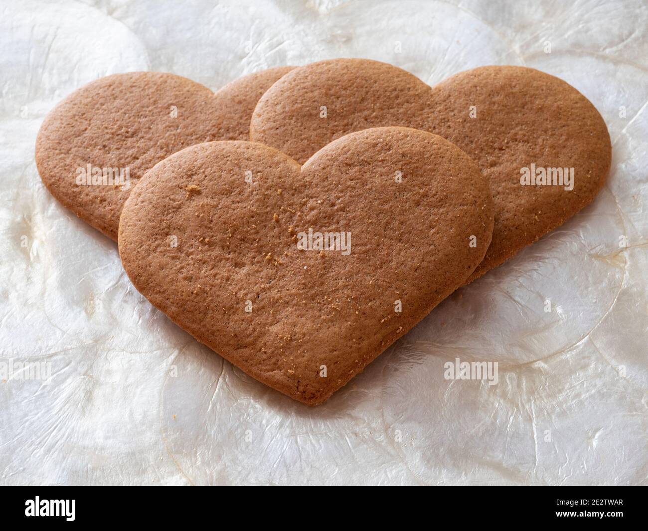 Drei herzförmige Kekse bilden ein Herz zwischen allen Stockfoto