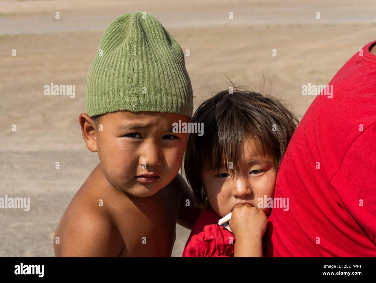 Olgii, Mongolei - 7. August 2019: Familie auf dem Motorrad mit zwei kleinen Kindern in der Steppe der Mongolei. Stockfoto