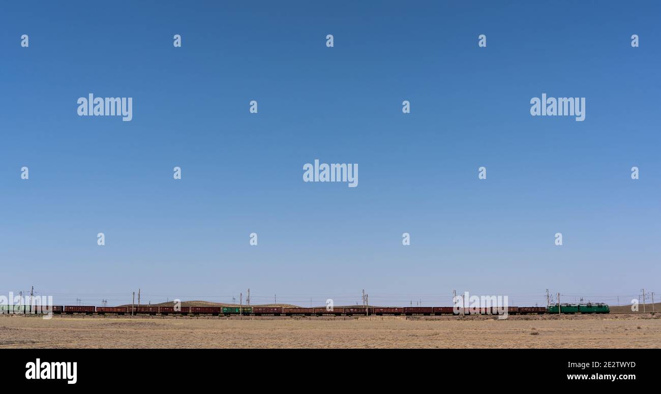 Alakol, Kasachstan - 22. Juli 2019: Güterzug in der Steppe und Wüste von Kasachstan. Stockfoto
