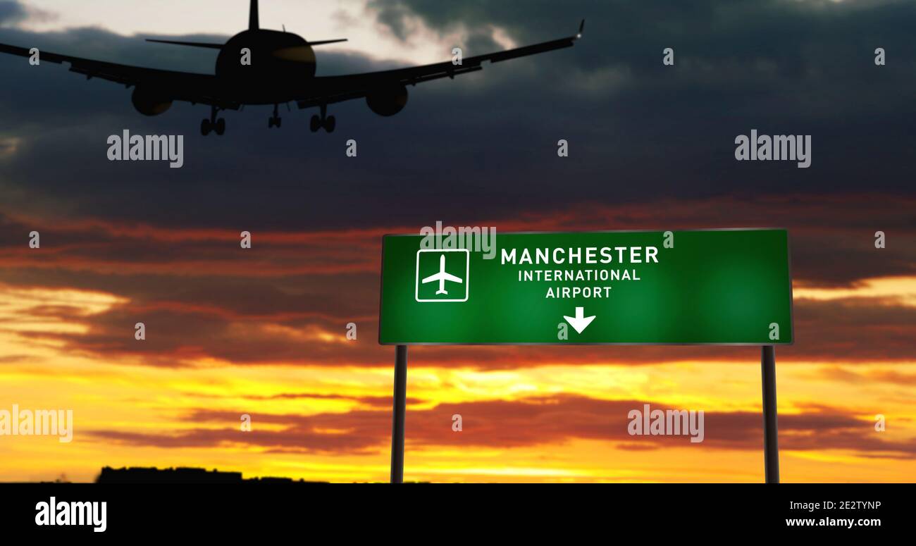 Flugzeug Silhouette Landung in Manchester, England, GB, Vereinigtes Königreich. City Ankunft mit Flughafen Richtung Schild und Sonnenuntergang im Hintergrund. Auslöseweg A Stockfoto