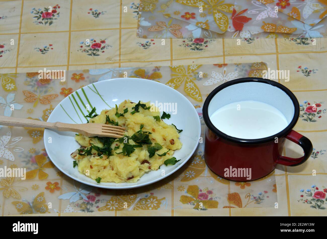 Kartoffelpüree mit Speck und Schnittlauch und einem Glas Sauerteig Stockfoto