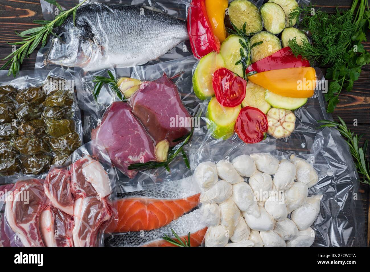 Produkte in Vakuumverpackung, auf einem Holzbrett. Gemüse, Fischfleisch, Dolma, Kurza. Quarantäne-Pandemie Stockfoto