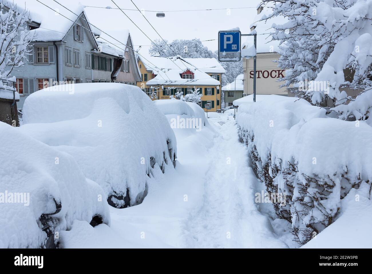 Sankt Gallen, Schweiz - 15. Januar 2021: Geparkte Autos im Schnee begraben Stockfoto