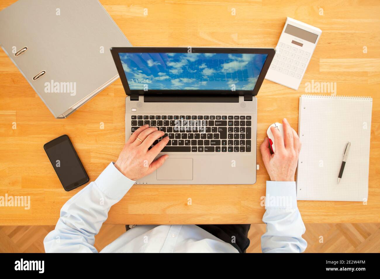 Geschäftsleute, die von zu Hause aus mit Laptop, Smartphone und Rechner arbeiten - Blick von oben - konzentrieren sich auf die Tastatur Stockfoto