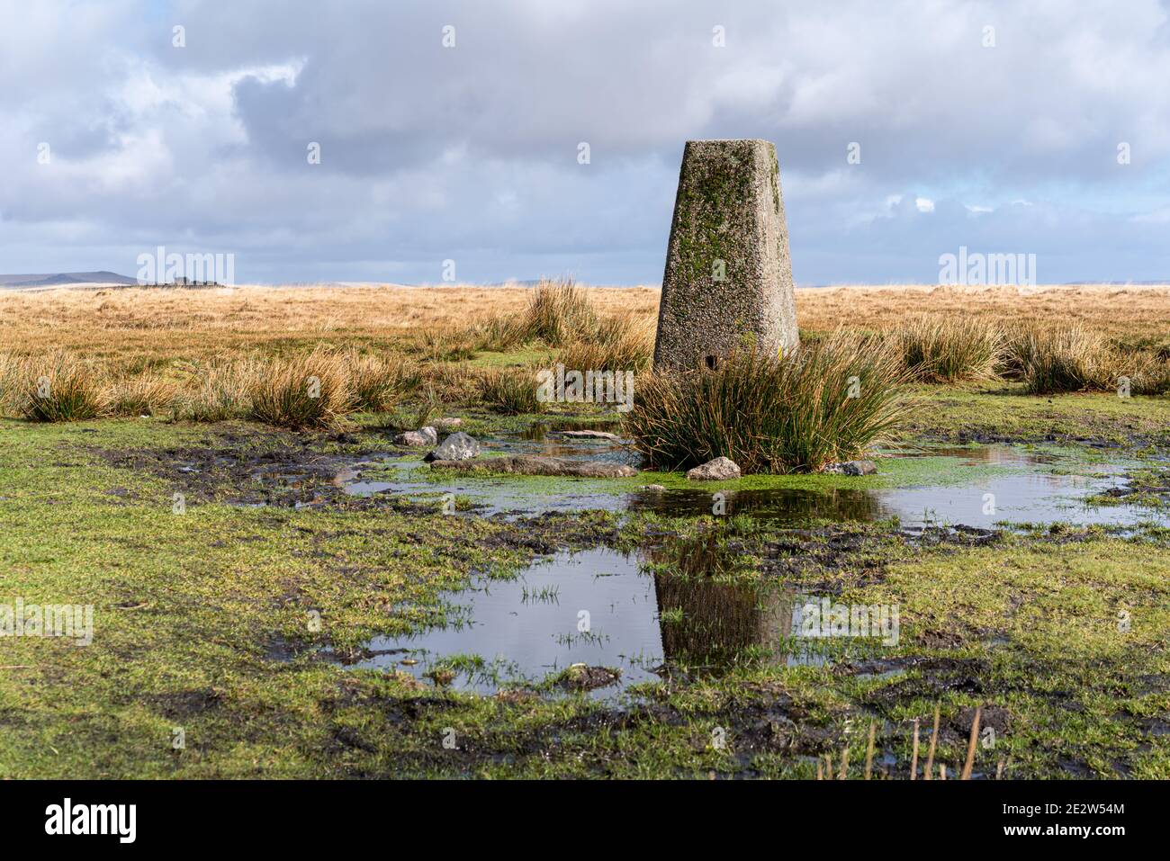 Ordnance Survey trig Point auf 445m auf Dartmoor mit South Hessary Tor dahinter. Stockfoto