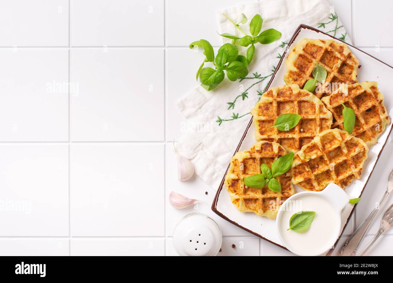 Hausgemachte Zucchini Waffeln mit Käse, Sause und Blatt Basilikum auf weißem Hintergrund. Konzept der Keto Ernährung Lebensmittel. Selektiver Fokus. Stockfoto