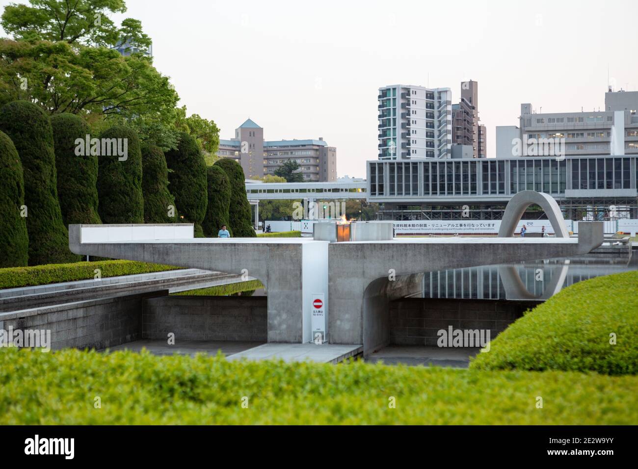 Das Cenotaph im Hiroshima Peace Memorial Park, Hiroshima, Japan, am frühen Abend. Blick auf das Museum. Stockfoto