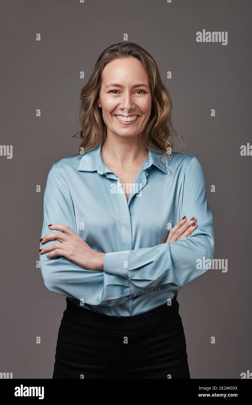 Retrato en estudio de mujer empresaria sobre fondo gris. Stockfoto
