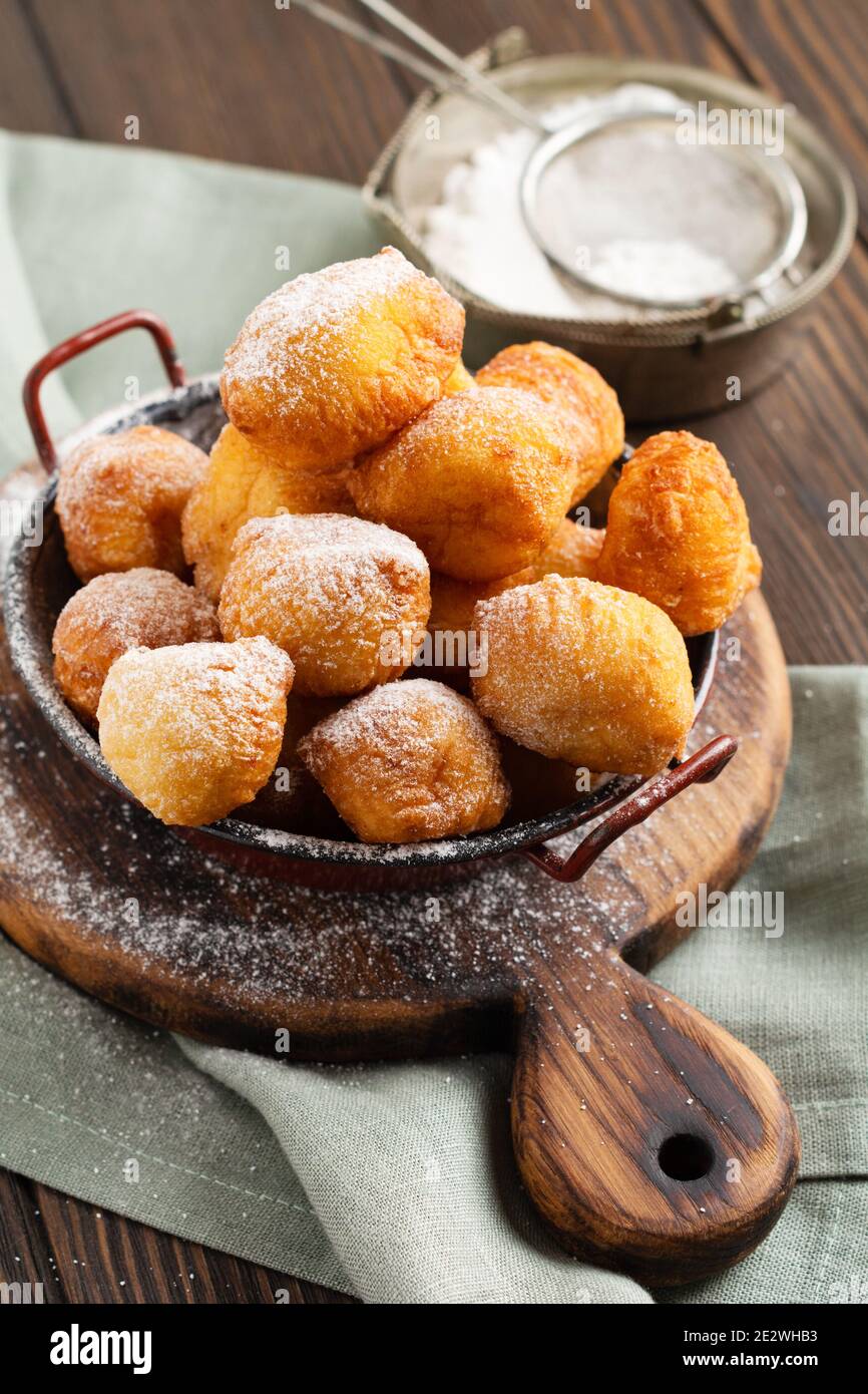 Kleine Donuts. Hausgemachte Quark gebratene Kekse in Fett und bestreut mit Puderzucker in einem Vintage-Teller auf einem hellen Hintergrund. Selektiver Fokus. Stockfoto