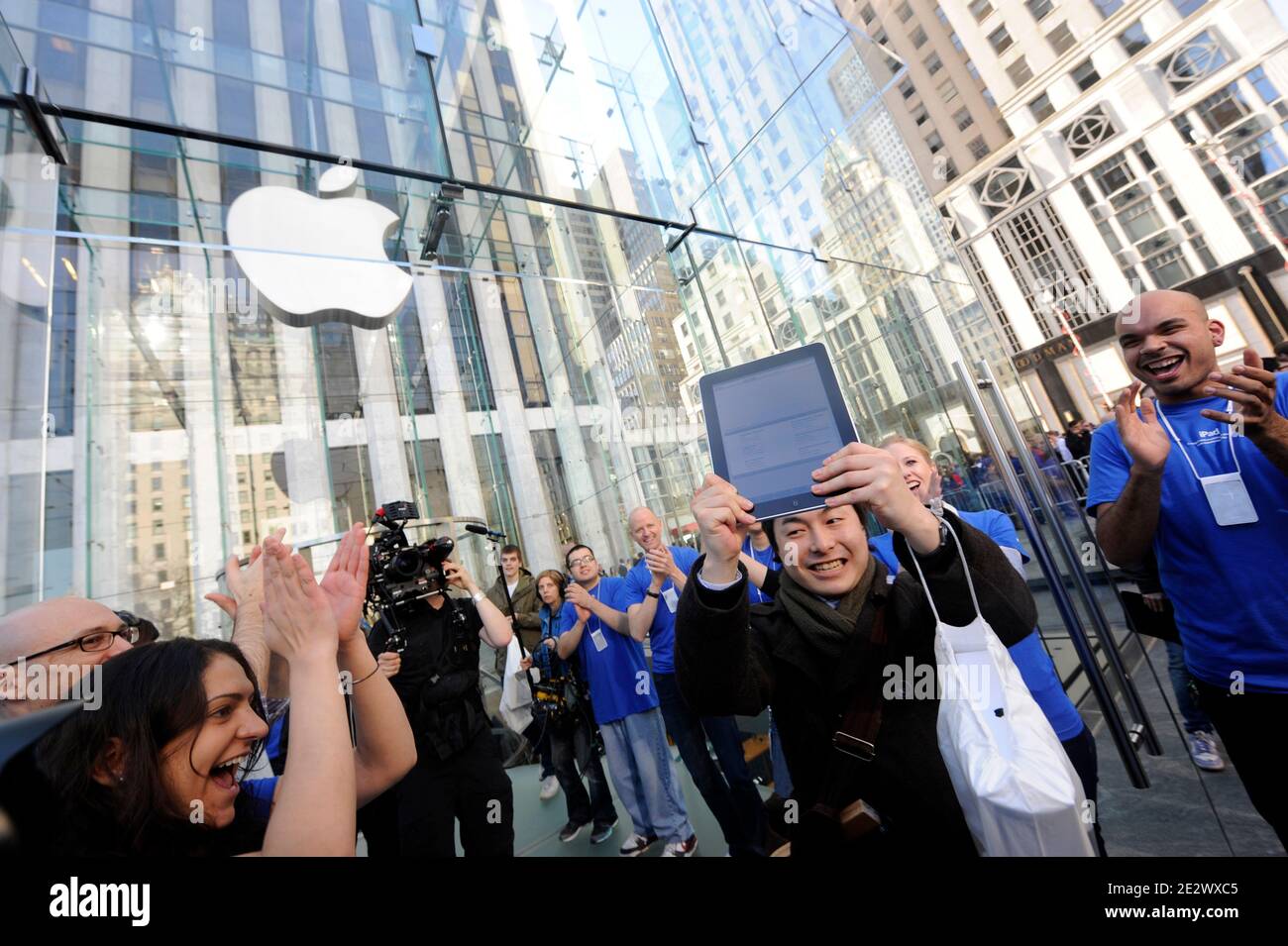 Am 3. April 2010 kommt ein früher Kunde aus dem Apple Store auf der Fifth Avenue mit dem neuen iPad von Apple Inc in New York City, NY, USA. Hunderte Reihen sich vor dem NYC Flagship Store des Technologieunternehmens an, um zu den ersten in der Welt zu gehören, die das Gerät erworben haben. All diese ersten iPad Käufer wurden durch die Fähigkeit, elektronische Bücher lesen, Video ansehen und laufen eine Vielzahl von nützlichen oder unterhaltsamen Anwendungen gezogen. Foto von Mehdi Taamallah/ABACAPRESS.COM Stockfoto