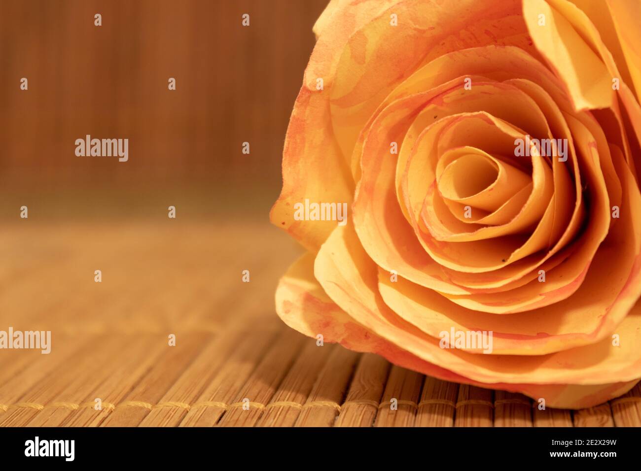 Nahaufnahme der Rosenblüte aus Papier auf Holztisch liegend mit Kopieplatz. Romantisches Konzept Stockfoto