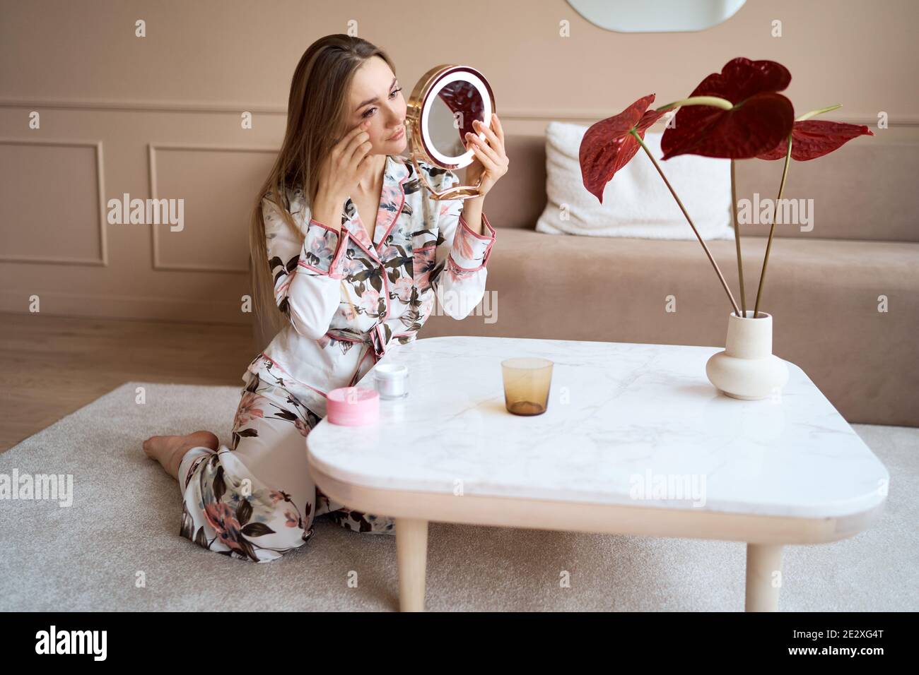 Attraktive Frau im Schlafanzug Anwendung Gesichtscreme. Attraktive junge Frau in Pyjama Anwendung feuchtigkeitsspendende Creme auf das Gesicht. Frisch vom Morgen Stockfoto