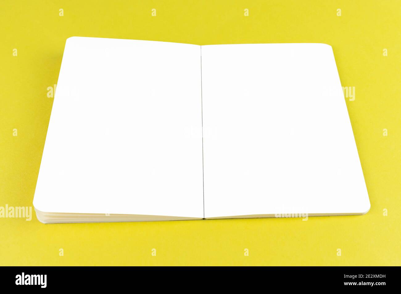 Offenes Copybook Modell auf gelbem Hintergrund mit weißen Seiten Editierbar Stockfoto