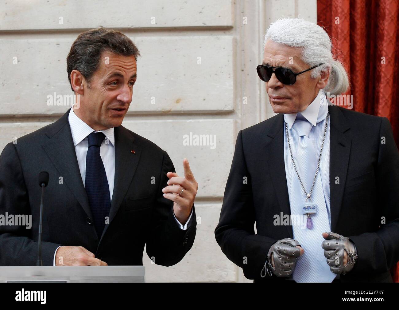 Der deutsche Modedesigner Karl Lagerfeld (R) hört zu, als er am 3. Juni 2010 im Elysee-Palast in Paris, Frankreich, das Kommandeurskreuz der Ehrenlegion (Croix de Commander de la Legion d'Honneur) von Frankreichs Präsident Nicolas Sarkozy empfängt. Foto von Jacky Naegelen/Pool/ABACAPRESS.COM Stockfoto