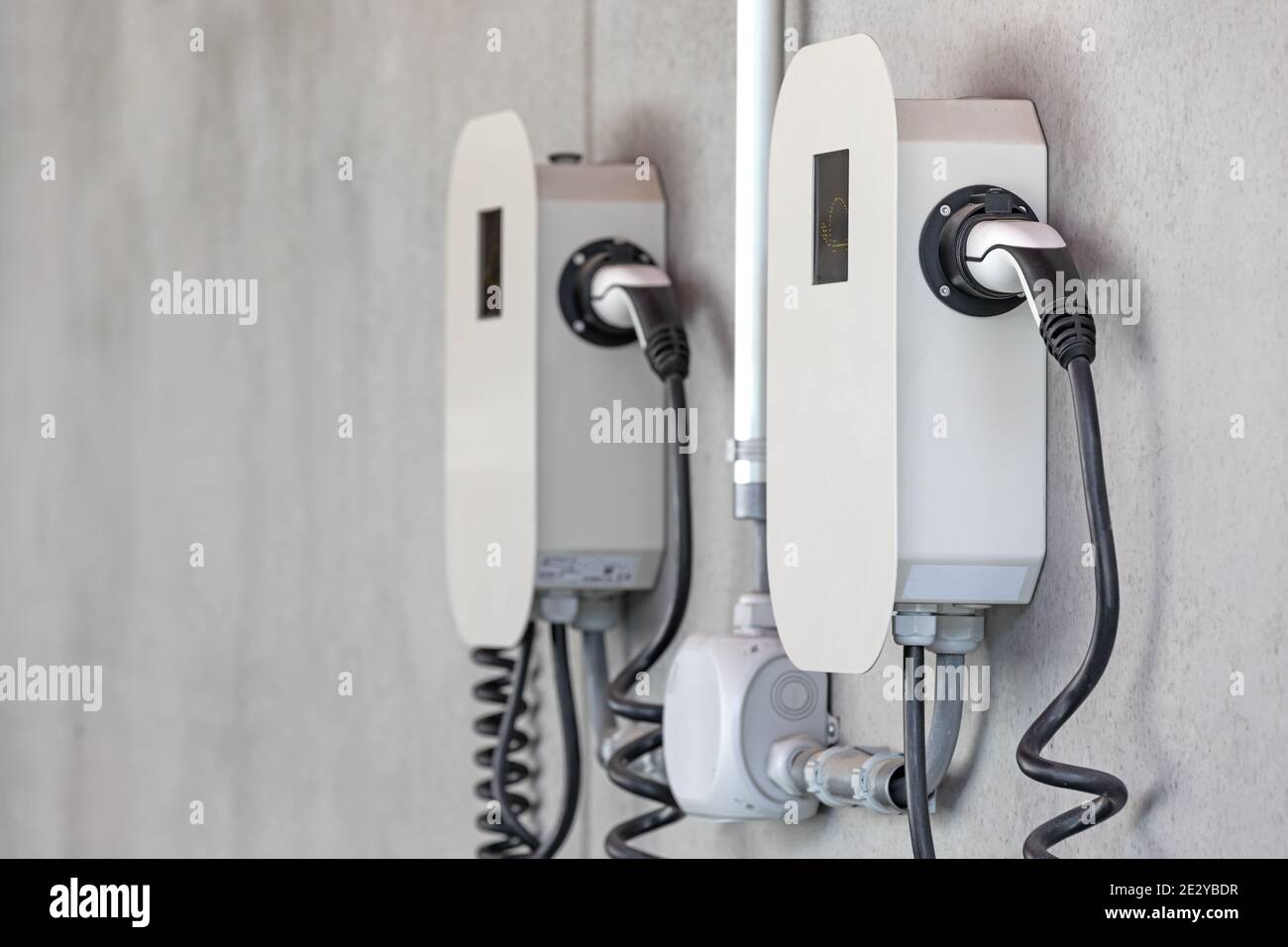 Elektrisches Ladegerät an Betonwand Stockfoto