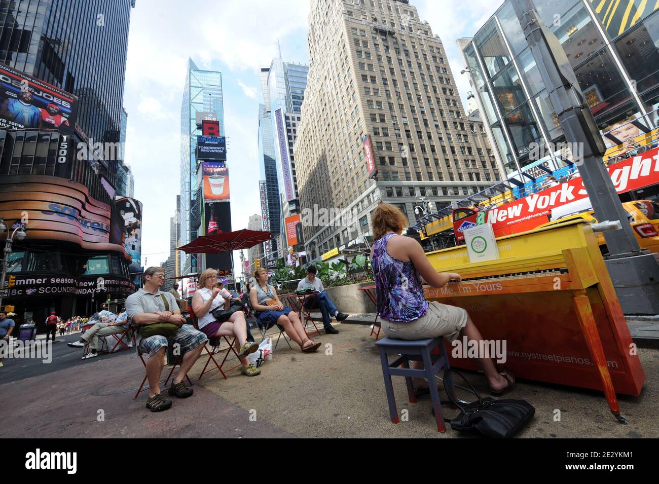 Eine Frau spielt Klavier am Times Square von New York, Montag, 23. Juni 2010. Das Klavier, eines von 60, ist Teil einer Kunstinstallation, die durch die Welt tourt und ihren ersten US-Aufenthalt in New York macht. Das Konzept hat mehr als 130 Klaviere in Parks, Plätzen und Busbahnhöfen in Städten von London bis Sydney, Australien. Foto von Mehdi Taamallah/ABACAPRESS.COM Stockfoto