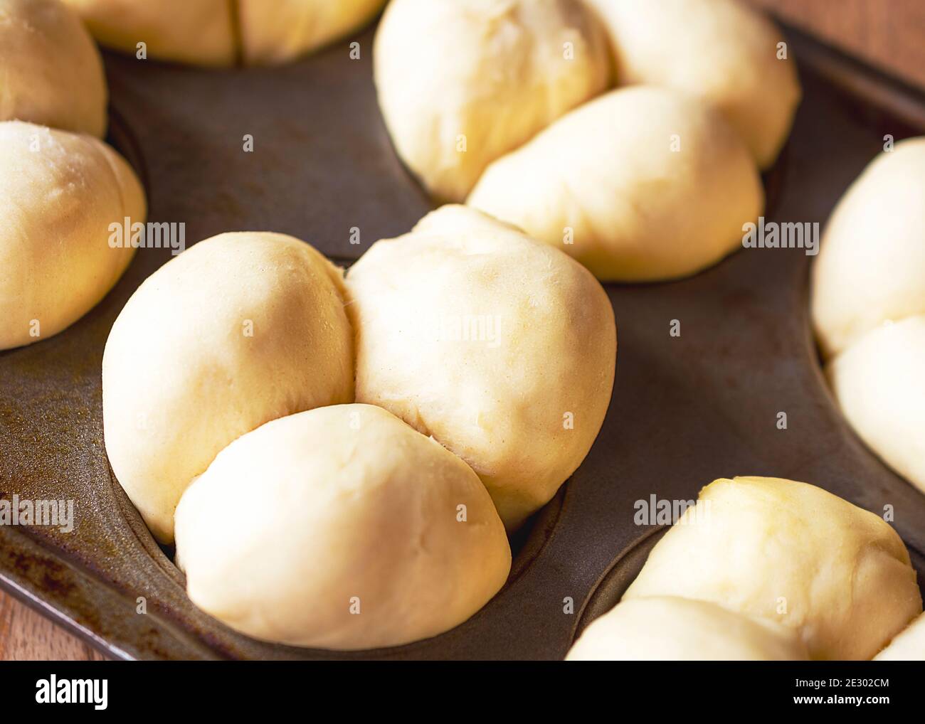 Kleeblatt Essrolle Teig hebt sich in Muffin Dosen. Nahaufnahme. Stockfoto