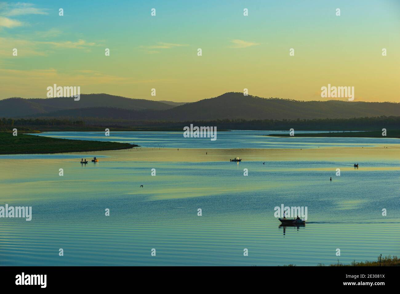Stimmungsvoller Blick auf Lake Callide und Fischerboote bei Sonnenaufgang, Biloela, Queensland, QLD, Australien Stockfoto