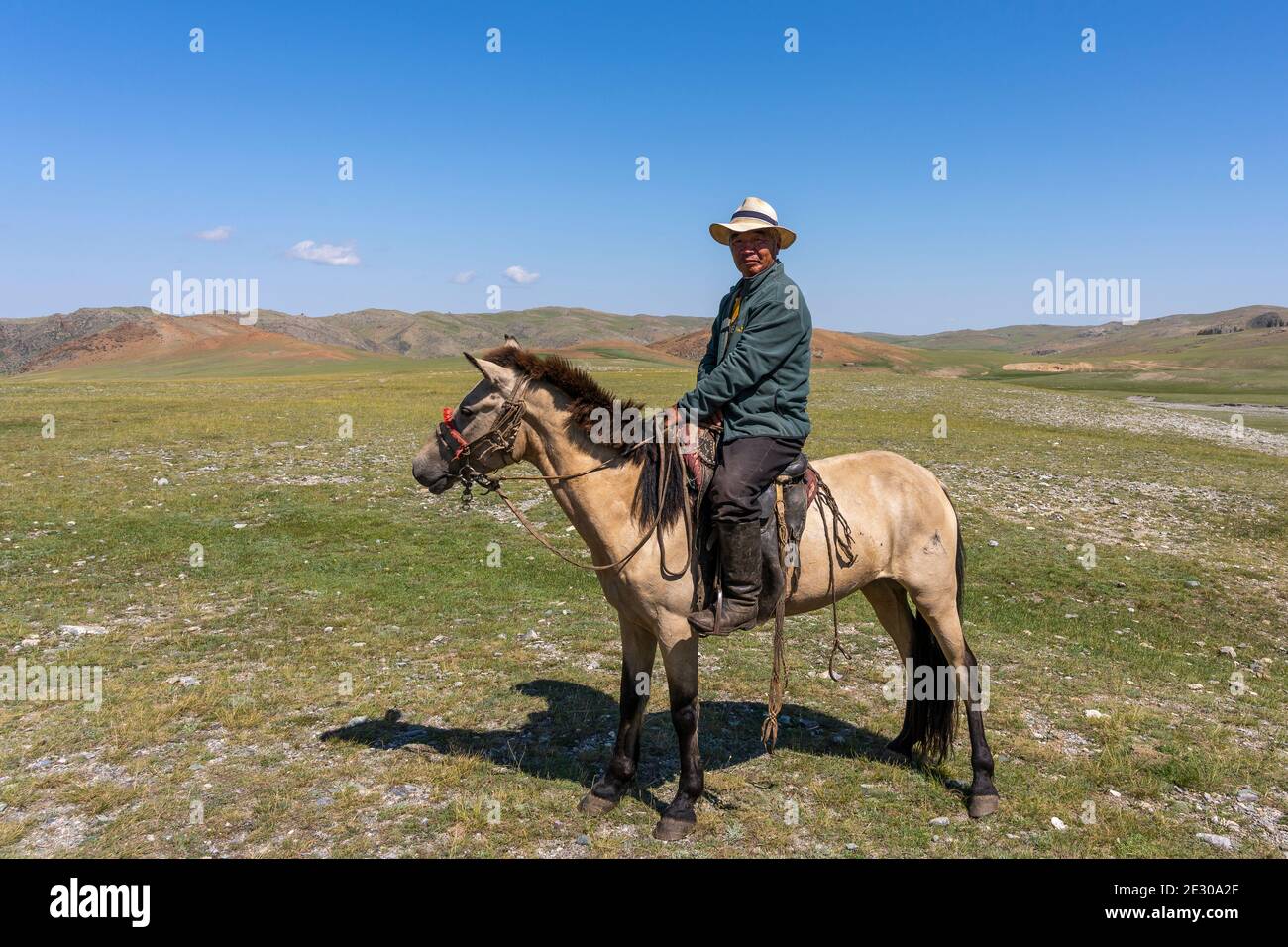 Tsagaanhairhan, Mongolei - 9. August 2019: Mongolischer Hirte zu Pferd mit Hut und auf der Steppe der Mongolei. Stockfoto