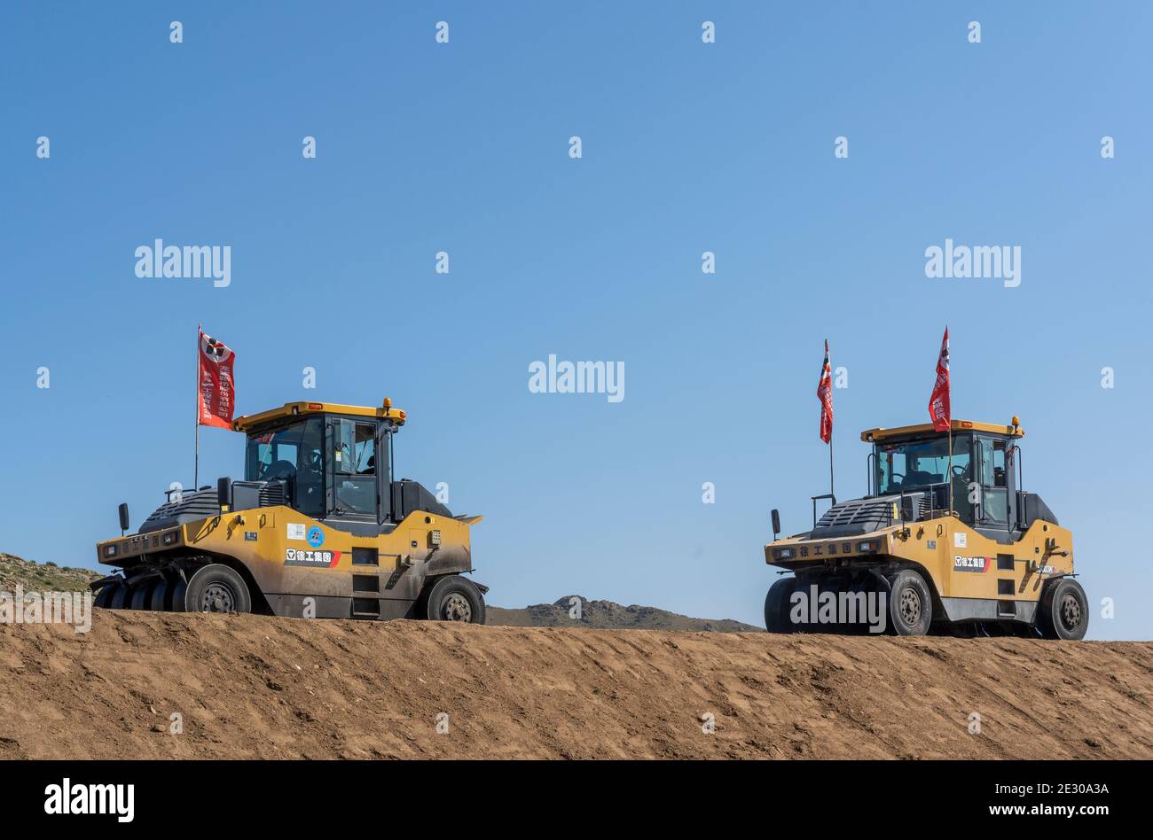 Numrug, Mogolia - 10. August 2019: Bau einer neuen Straße, der Seidenstraße, von chinesischen Unternehmen in der Mongolei mit schweren gelben Maschinen, wie Asphaltwalze Stockfoto