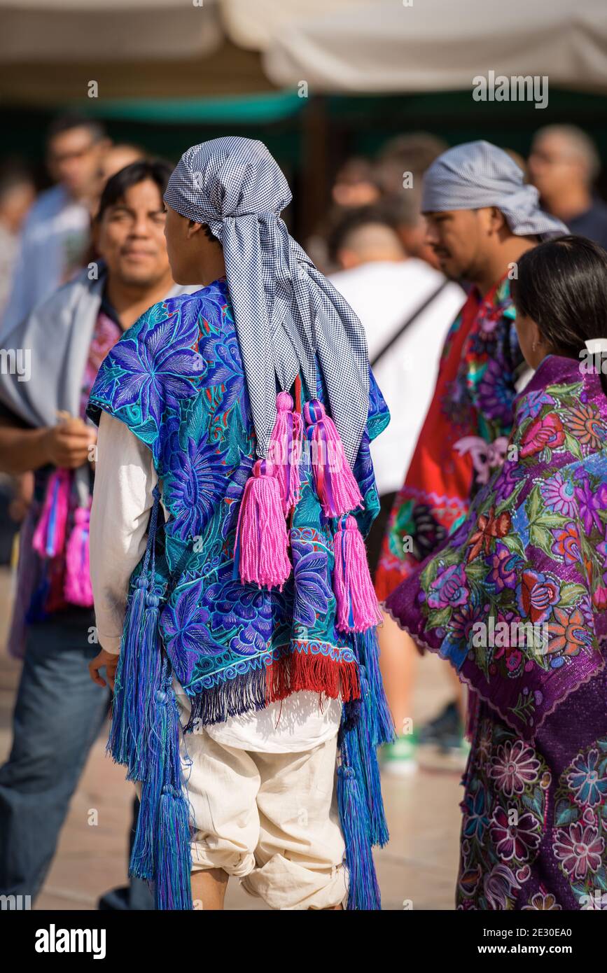 Gruppe von Mexikanern mit traditioneller Kleidung mit floraler Struktur und kariertem Kopfschmuck mit Fuchsia-Quasten, Dorf Zinacantan, Chiapas, Mexiko. Stockfoto