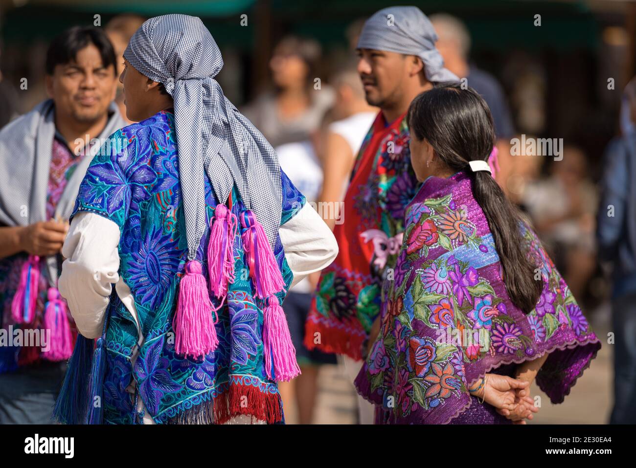 Gruppe von Mexikanern mit traditioneller Kleidung mit floraler Struktur und kariertem Kopfschmuck mit Fuchsia-Quasten, Dorf Zinacantan, Chiapas, Mexiko. Stockfoto