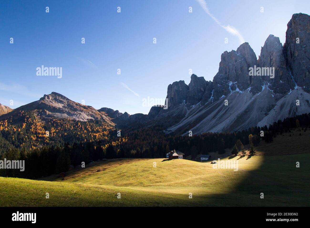 Blick auf die Sonne hinter den Geislerbergen von der Glatschalm. Villnösser Tal, Dolomiten, Trentino-Südtirol, Italien. Stockfoto