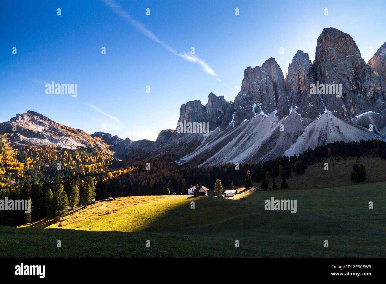 Blick auf die Sonne hinter den Geislerbergen von der Glatschalm. Villnösser Tal, Dolomiten, Trentino-Südtirol, Italien. Stockfoto