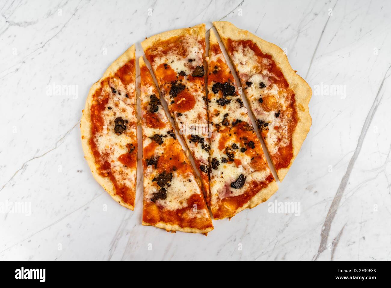 Pizza in Scheiben, Trüffelpilze mit Tomatensauce und Käse auf weißem Marmor Hintergrund Stockfoto