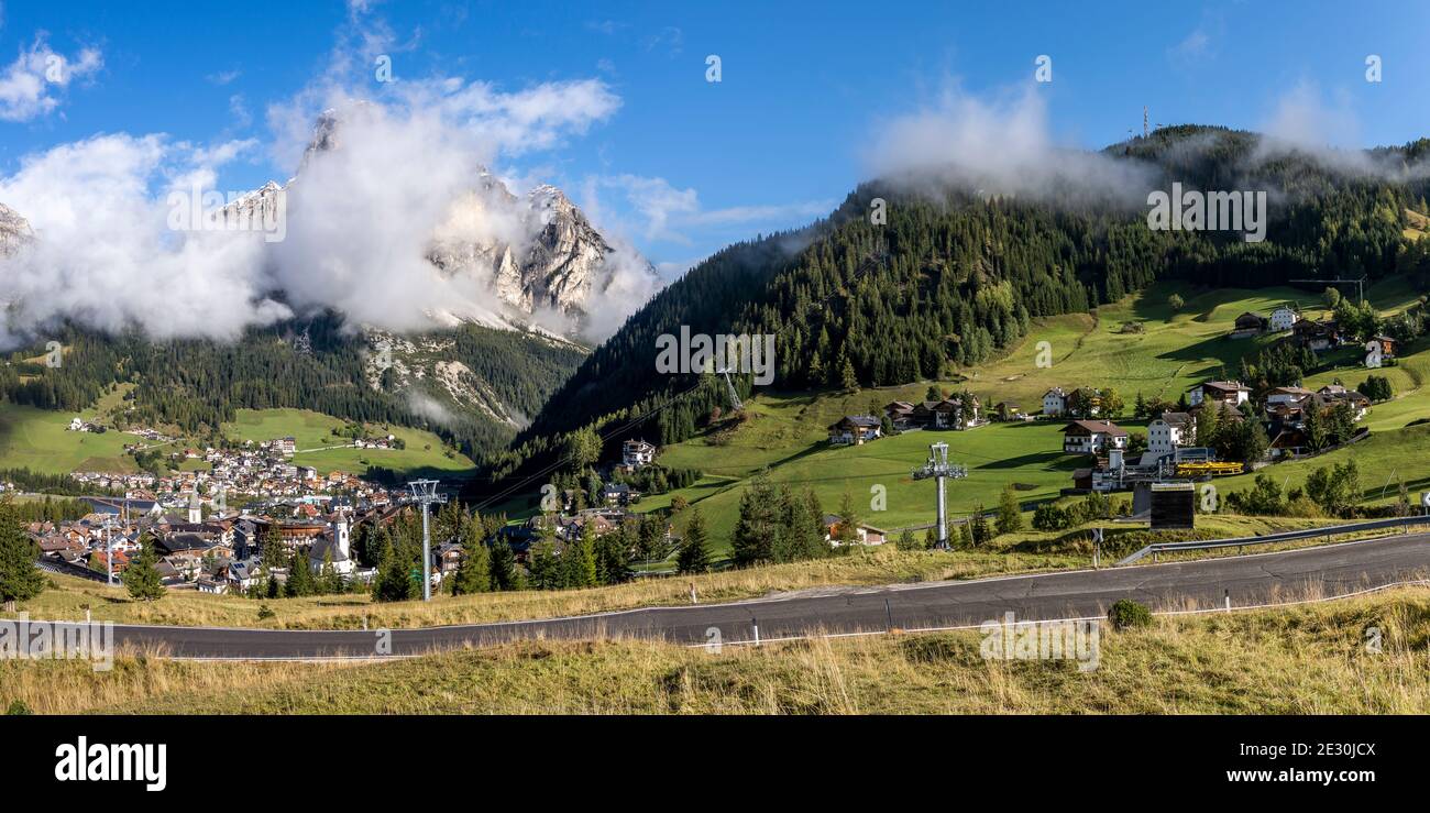 Panorama von Badia, Alta Adige in der Nähe von Corvara Tal mit Skilift, Bauernhof und Wald mit den Dolomiten Bergen mit Schnee im Hintergrund. Stockfoto