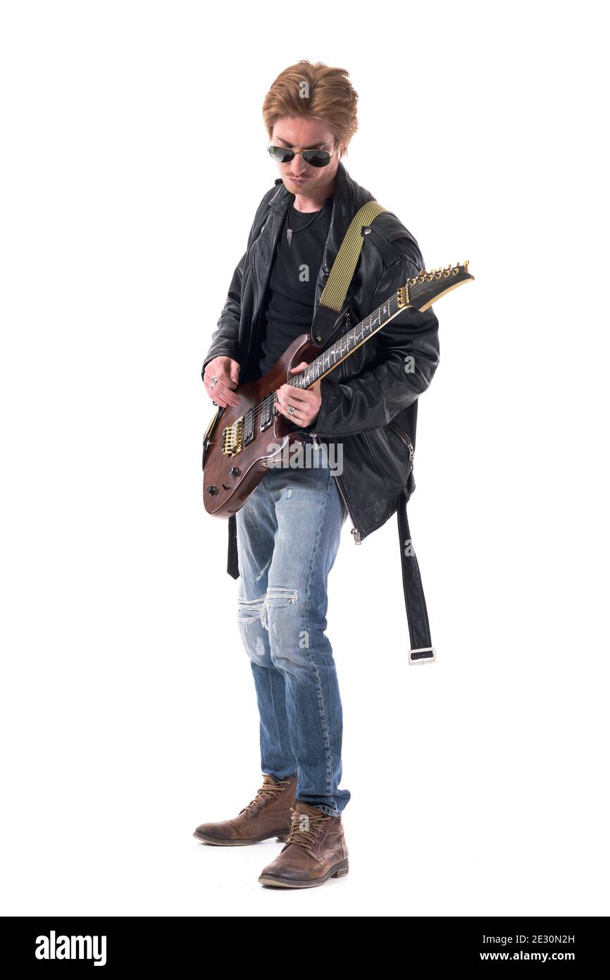 Seitenansicht des Rockmusikers, der E-Gitarre in stilvoller Kleidung spielt. Ganzkörper isoliert auf weißem Hintergrund. Stockfoto