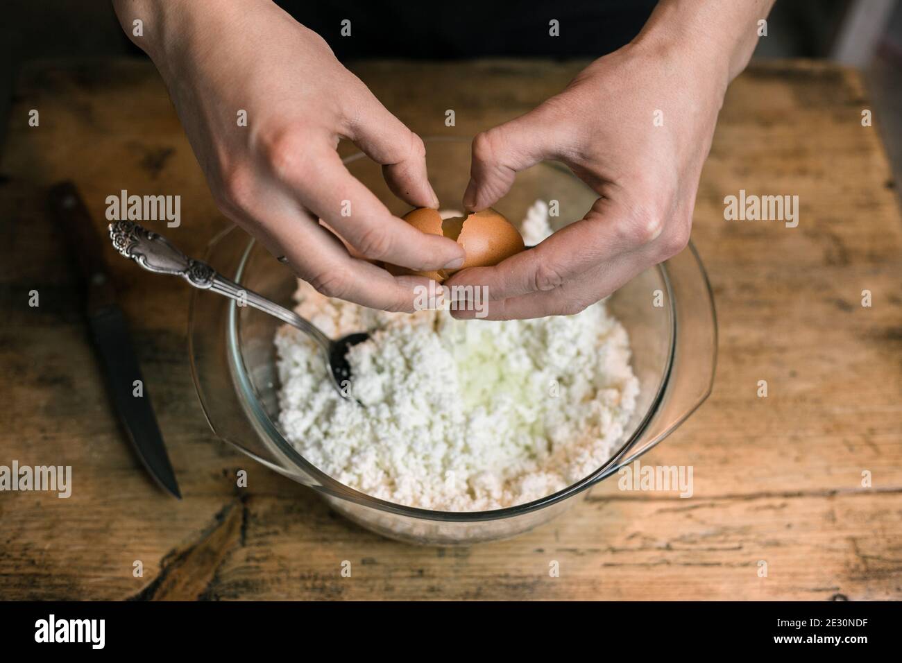 Bricht ein Hühnereier und fügt dem Quark hinzu Stockfoto