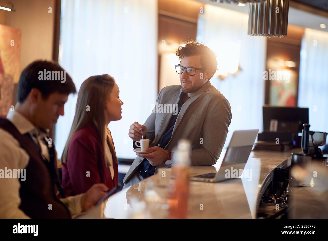 Junge Geschäftsleute genießen angenehme Gespräche in einer Kaffeepause in entspannter Atmosphäre an der Bar. Business, Leute, Bar Stockfoto