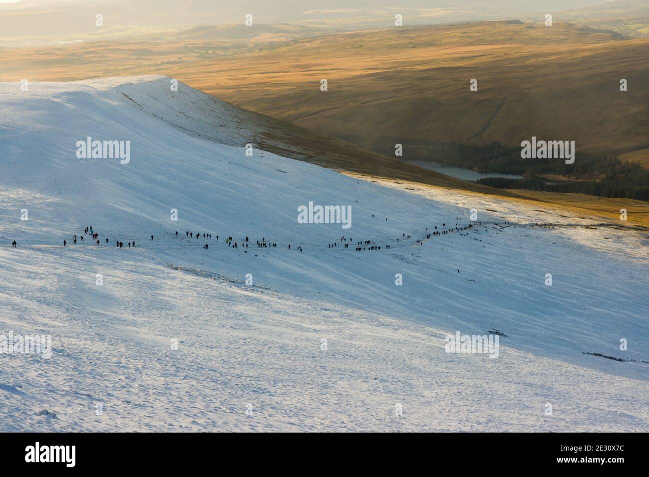 Lange Wanderschnur oberhalb der Schneelinie auf einem Bergpfad (Pen-y-Fan, Wales) Stockfoto