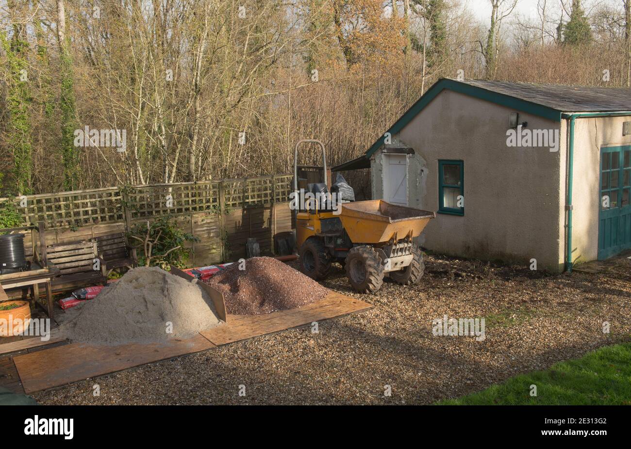 Baustelle mit einem Dumper Truck und Haufen Sand und Schotter zum Umbau eines Außengebäudes in Rural Devon, England, Großbritannien Stockfoto