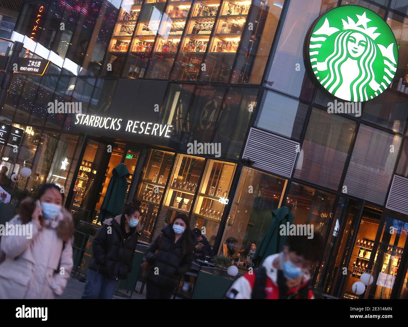 Peking, China. Januar 2021. Chinese Walk vorbei an einem Starbucks in der Innenstadt von Peking am Samstag, 16. Januar 2021. Chinas Präsident Xi Jinping hat den ehemaligen Chef von Starbucks Howard Shultz gebeten, den Handel zwischen Washington und Peking in einer seltenen Missive an einen ausländischen Wirtschaftsführer zu fördern, berichteten die staatlichen Medien diese Woche. Foto von Stephen Shaver/UPI Kredit: UPI/Alamy Live Nachrichten Stockfoto