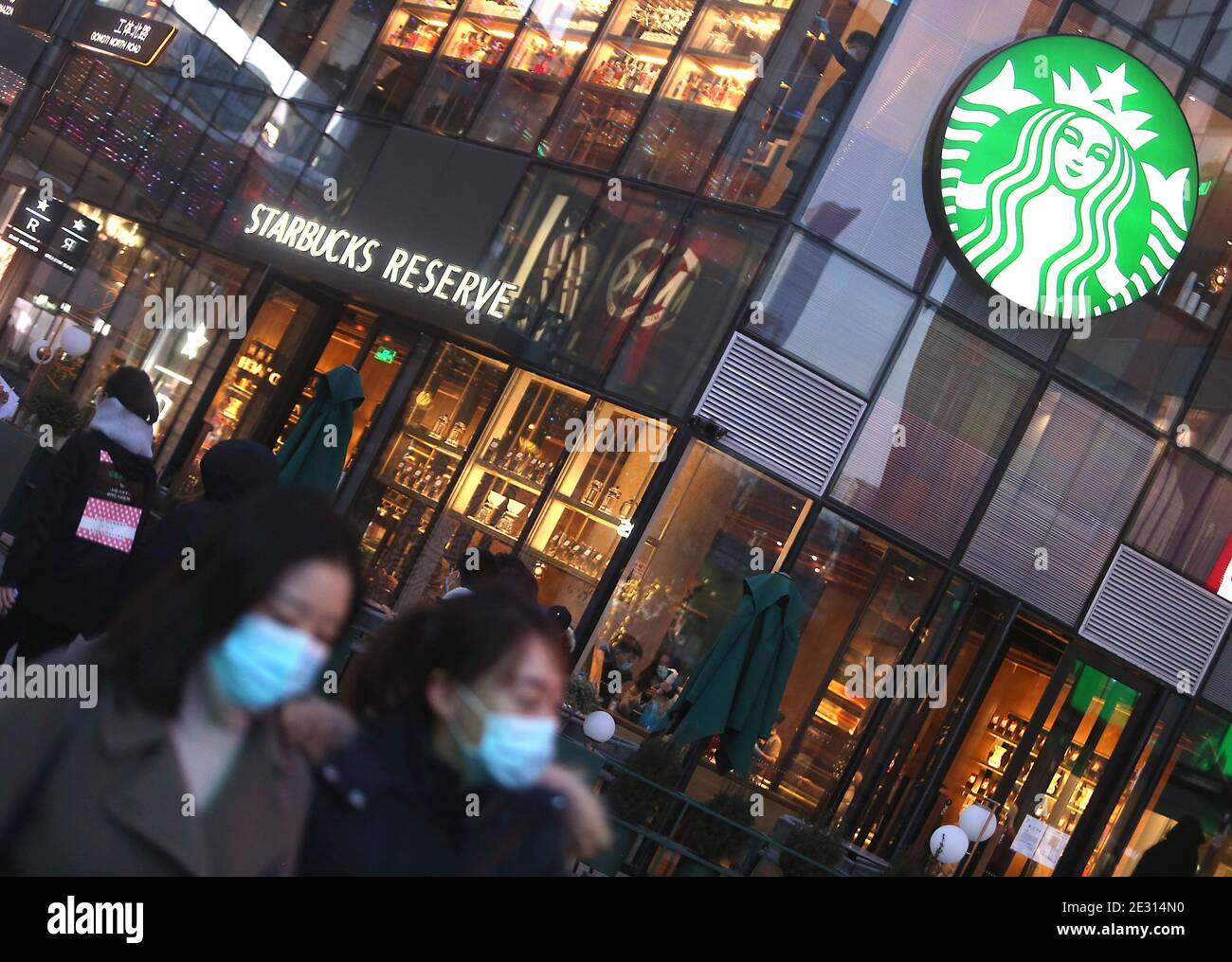 Peking, China. Januar 2021. Chinese Walk vorbei an einem Starbucks in der Innenstadt von Peking am Samstag, 16. Januar 2021. Chinas Präsident Xi Jinping hat den ehemaligen Chef von Starbucks Howard Shultz gebeten, den Handel zwischen Washington und Peking in einer seltenen Missive an einen ausländischen Wirtschaftsführer zu fördern, berichteten die staatlichen Medien diese Woche. Foto von Stephen Shaver/UPI Kredit: UPI/Alamy Live Nachrichten Stockfoto