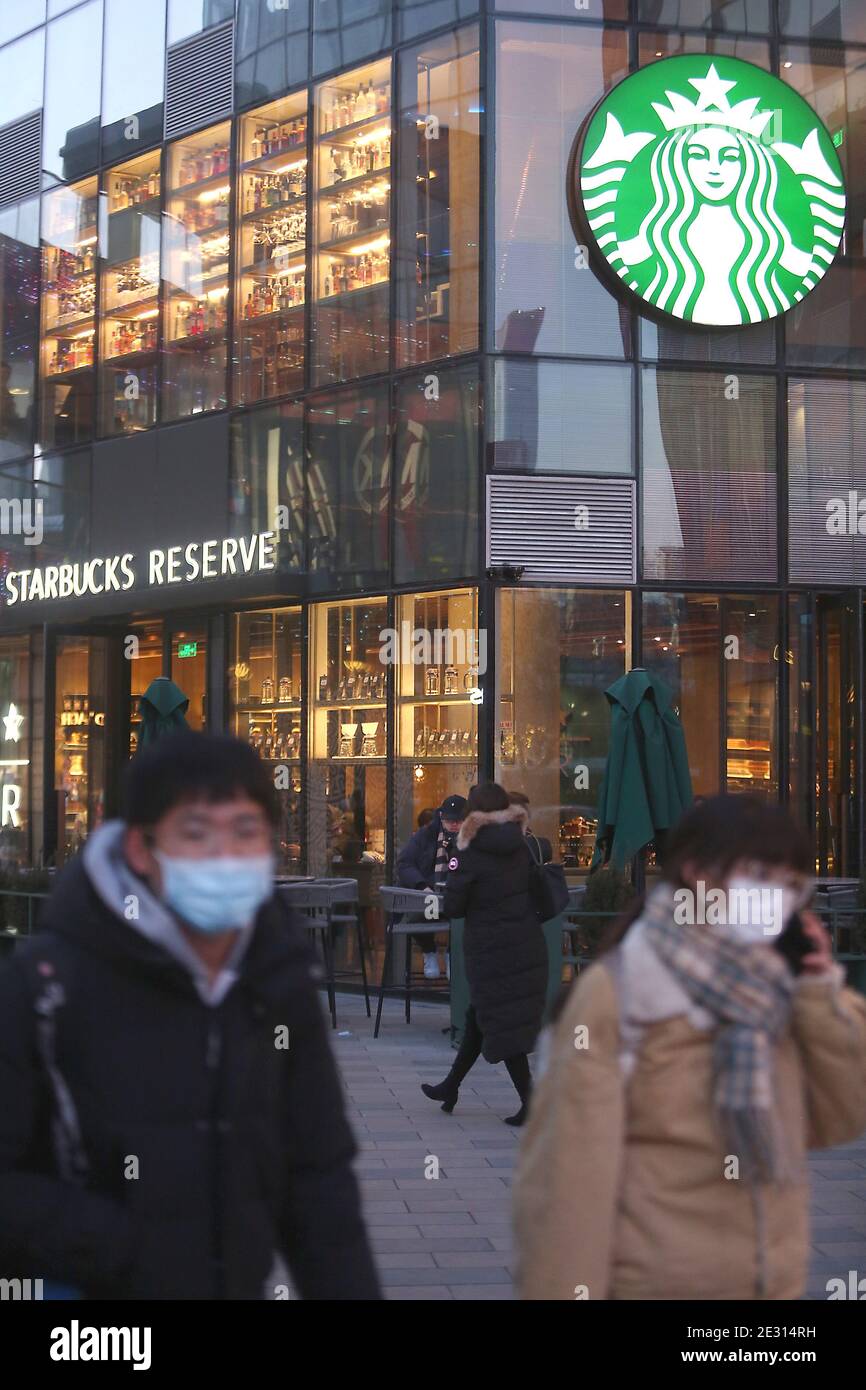 Peking, China. Januar 2021. Chinese Walk vorbei an einem Starbucks in der Innenstadt von Peking am Samstag, 16. Januar 2021. Chinas Präsident Xi Jinping hat den ehemaligen Chef von Starbucks Howard Shultz gebeten, den Handel zwischen Washington und Peking in einer seltenen Missive an einen ausländischen Wirtschaftsführer zu fördern, berichteten die staatlichen Medien diese Woche. Foto von Stephen Shaver/UPI Kredit: UPI/Alamy Live Nachrichten Stockfoto