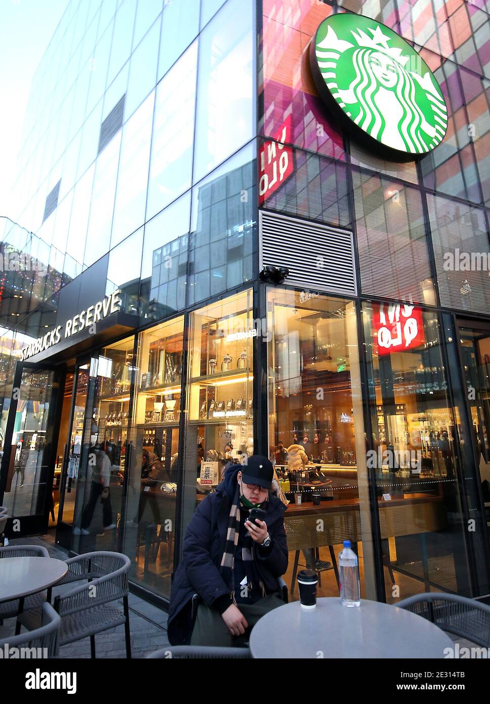 Peking, China. Januar 2021. Ein Chinese sitzt vor einem Starbucks in der Innenstadt von Peking am Samstag, 16. Januar 2021. Chinas Präsident Xi Jinping hat den ehemaligen Chef von Starbucks Howard Shultz gebeten, den Handel zwischen Washington und Peking in einer seltenen Missive an einen ausländischen Wirtschaftsführer zu fördern, berichteten die staatlichen Medien diese Woche. Foto von Stephen Shaver/UPI Kredit: UPI/Alamy Live Nachrichten Stockfoto