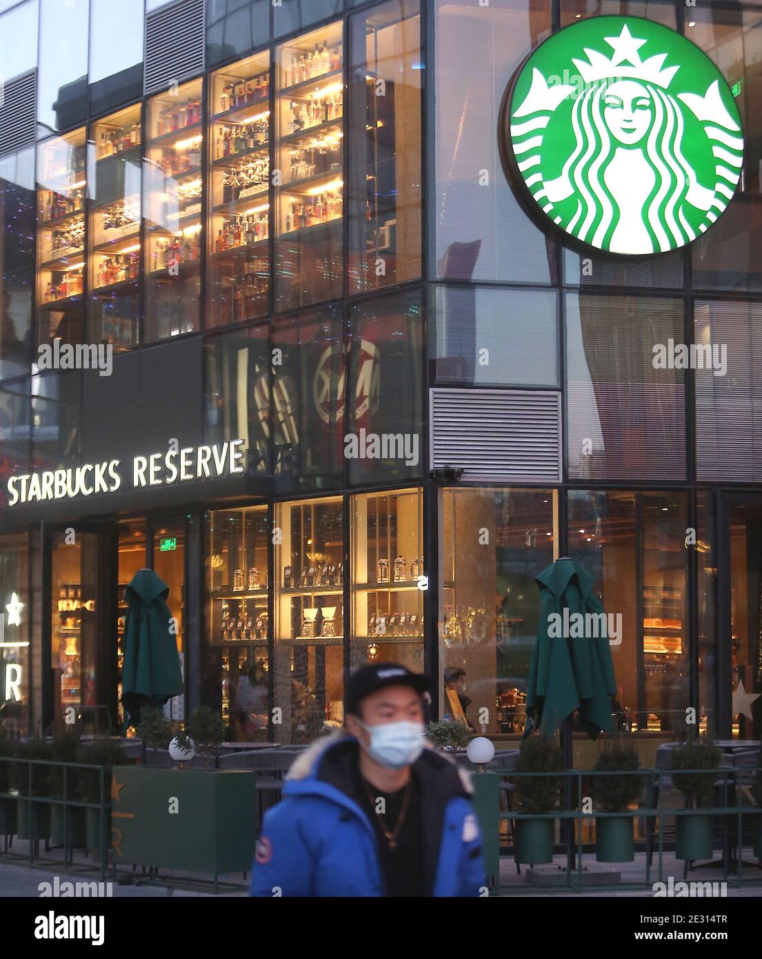 Peking, China. Januar 2021. Chinese Walk vorbei an einem Starbucks in der Innenstadt von Peking am Samstag, 16. Januar 2021. Chinas Präsident Xi Jinping hat den ehemaligen Chef von Starbucks Howard Shultz gebeten, den Handel zwischen Washington und Peking in einer seltenen Missive an einen ausländischen Wirtschaftsführer zu fördern, berichteten die staatlichen Medien diese Woche. Foto von Stephen Shaver/UPI Kredit: UPI/Alamy Live Nachrichten Stockfoto