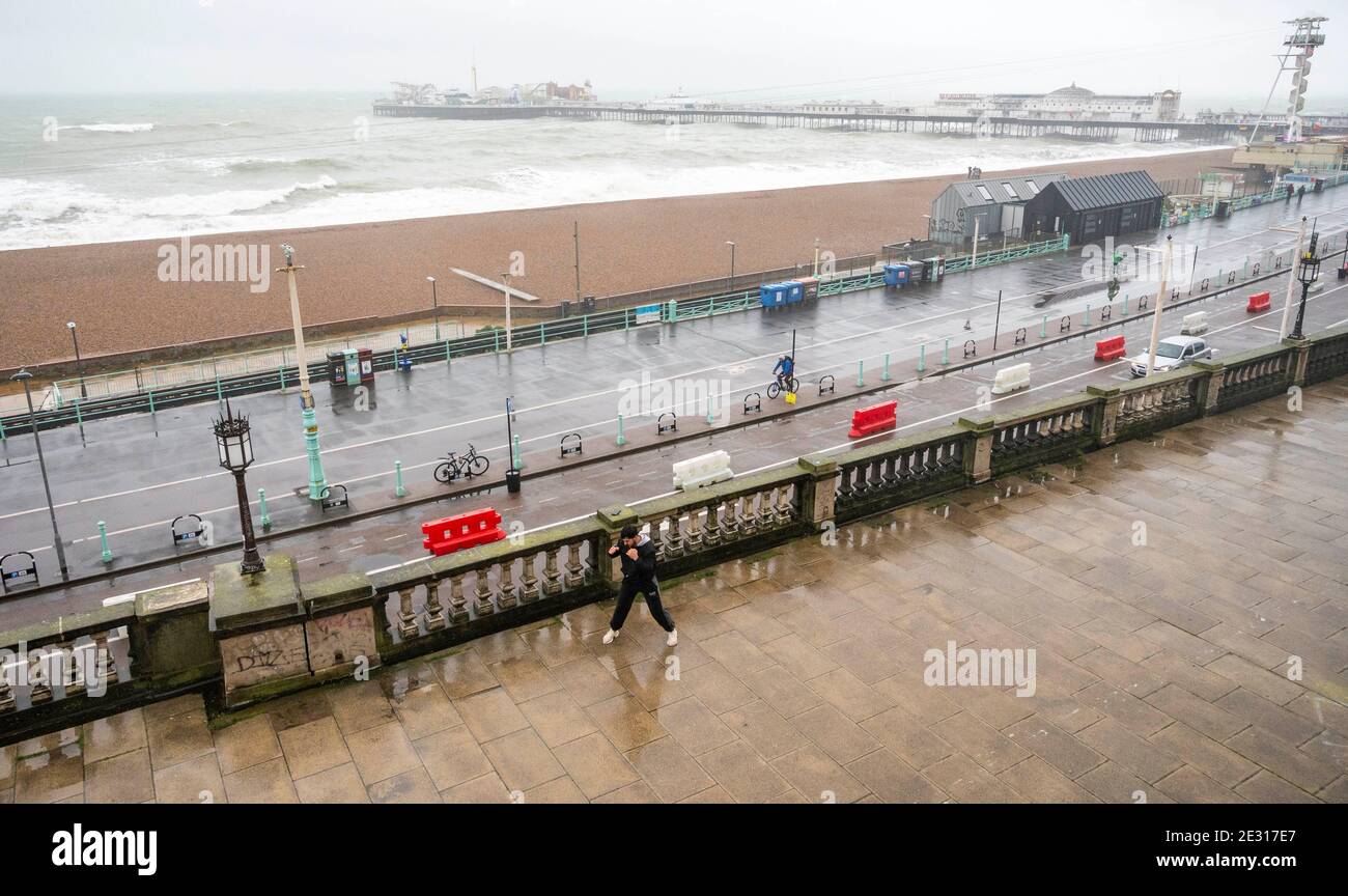Brighton UK 16. Januar 2021 - EIN junger Mann geht an einem nassen und windigen Tag an der Südküste durch sein Boxtraining an der Strandpromenade von Brighton, während die COVID-19 Sperrbeschränkungen in England weiter bestehen. : Credit Simon Dack / Alamy Live News Stockfoto