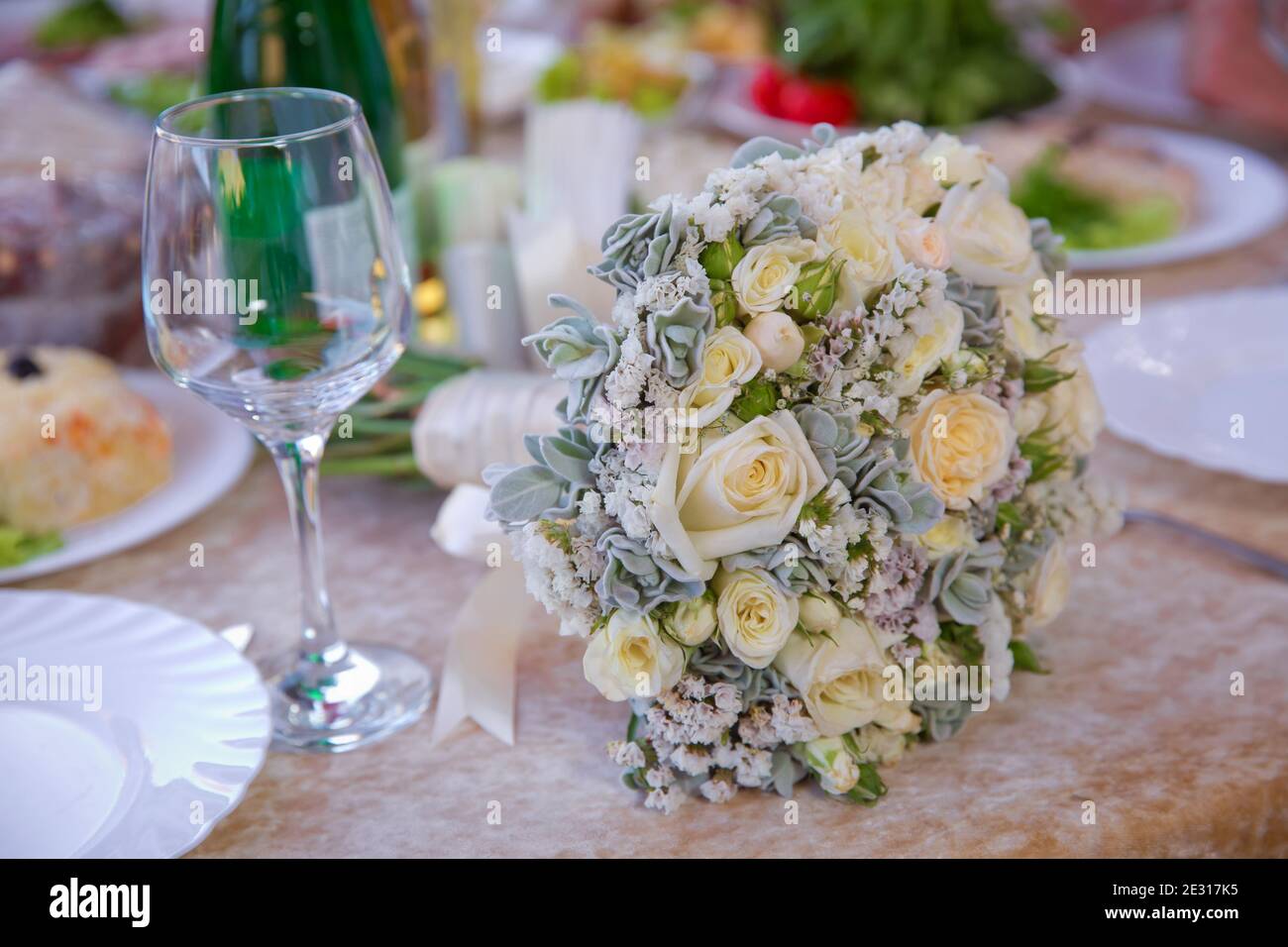 Ein Strauß weißer Hochzeitsblumen auf dem Tisch. Weiße Hochzeitsblumen in selektiver Fokus und verschwommener Hintergrund. Nahaufnahme Bild von leeren Gläsern i Stockfoto