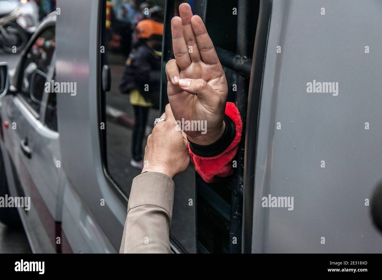 Während der Demonstration grüßt der verhaftete Pro-Demokratie-Protestler aus einem Polizeifahrzeug mit drei Fingern. Mindestens zwei Demonstranten wurden von der Polizei verhaftet, weil sie gegen das Notstandsdekret verstoßen hatten, als sie an einer Demonstration teilnahmen, weil sie am Siegessäule Botschaften gegen die Regierung auf einem 112 Meter langen Banner schrieben. Mehr als 30 der Demonstranten und regierungsfeindlichen Führer, die an den prodemokratischen Protesten teilgenommen haben, sind den Hauptanklagen nach Artikel 112 des thailändischen Strafgesetzbuches ausgesetzt, und einer von ihnen ist 16 Jahre alt. Die Demonstranten fordern Th Stockfoto