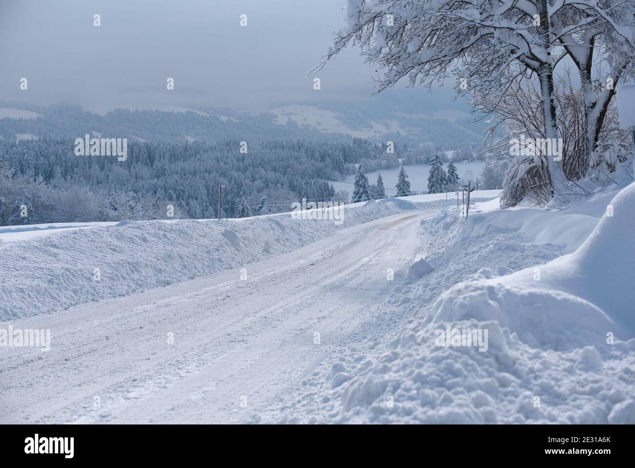 Scheidegg, Bayern, Deutschland, 15. Januar 2021: Schneesturm in Bayern. Blick auf die gereinigte Straße nach einem Schneekklon Stockfoto