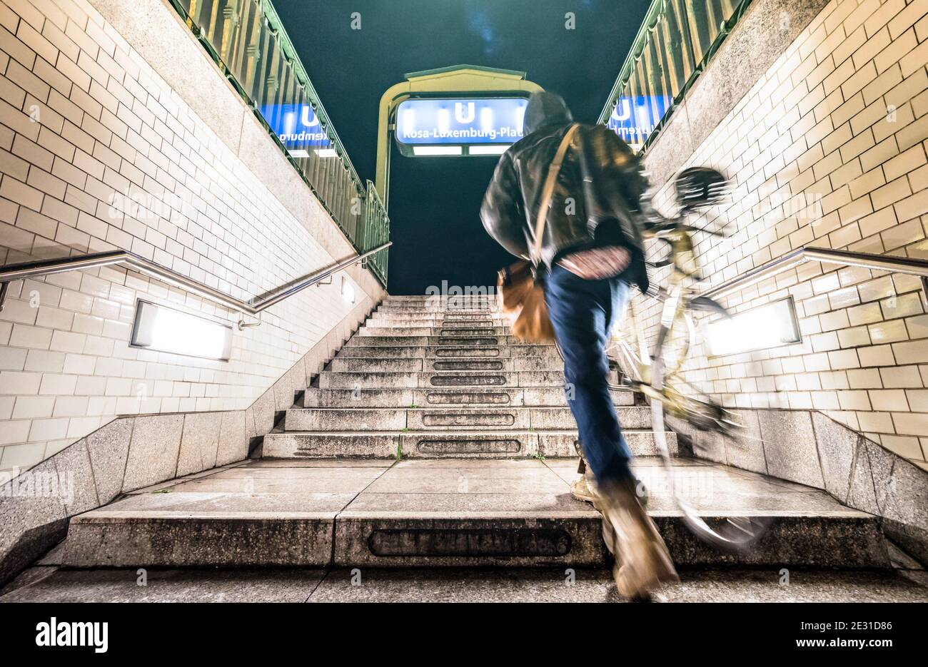 Verschwommener Unschärfer mit Fahrrad, der von Rosa Luxemburg ausfährt U-Bahn-Station in Berlin - Urban life travel concept with Straßenmann in der U-Bahn Stockfoto