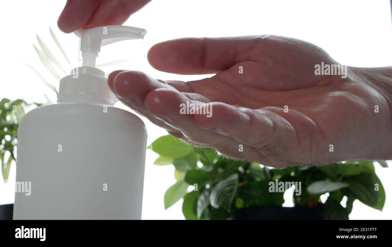 Der Mensch reinigt und desinfiziert seine Hände mit antibakterieller Lösung Stockfoto