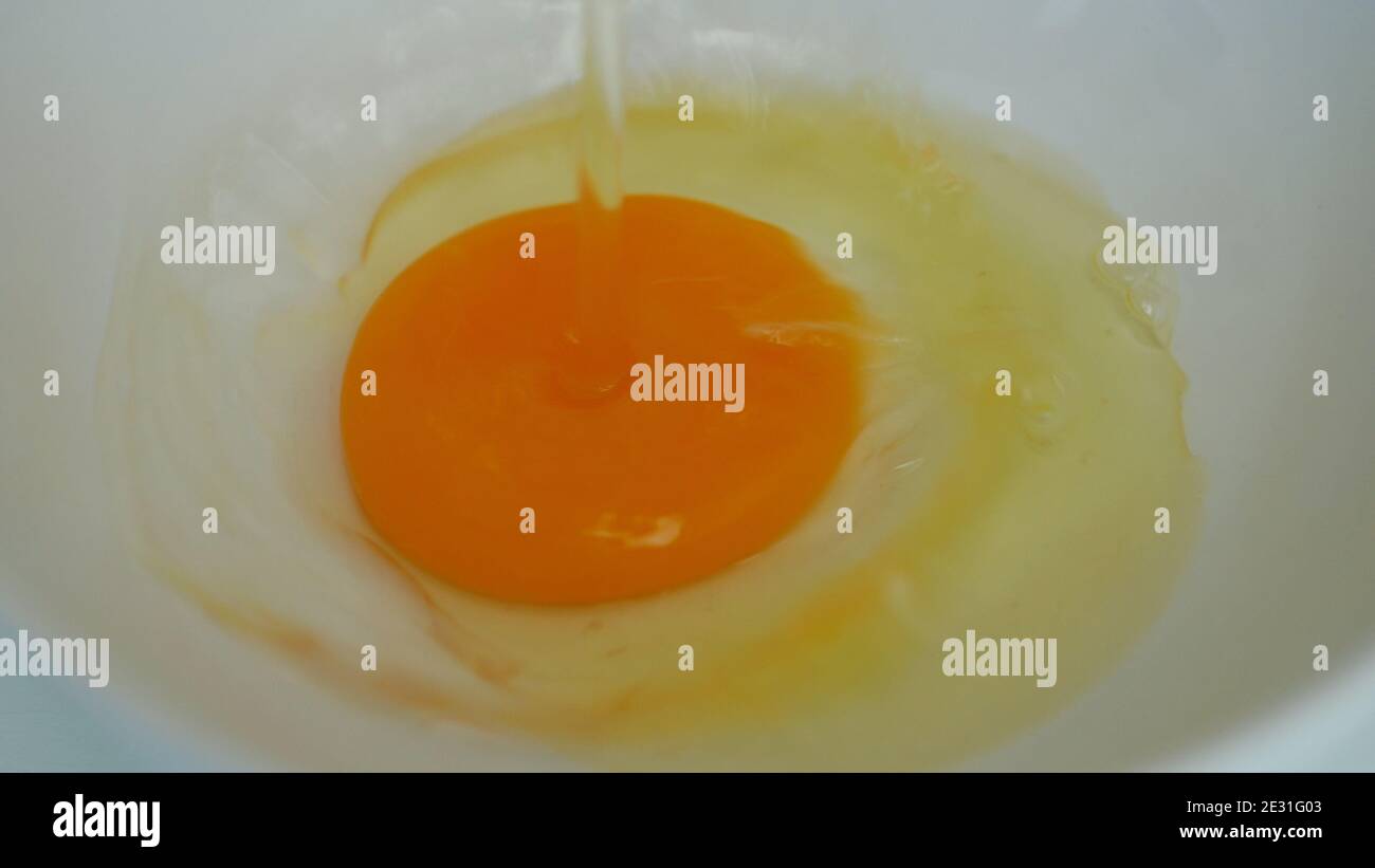 Nahaufnahme Bild mit einem frischen Ei Weiß und Eigelb Vorbereitet zum Kochen in der Küche zum Frühstück Stockfoto